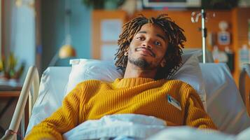 Mens met dreadlocks houdende in ziekenhuis bed foto