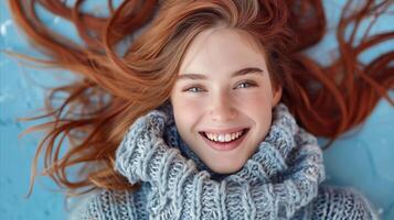glimlachen jong vrouw met vloeiende kastanjebruin haar- aan het liegen Aan blauw achtergrond foto