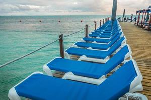 houten pier en lange blauwe stoelen met niemand