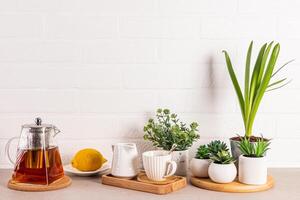 thee ceremonie items reeks Aan keuken steen aanrecht met ingemaakt planten wit steen muur. een kopiëren ruimte. keuken achtergrond foto