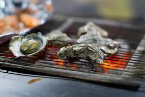 grillen lekkernijen, oester zeevruchten, barbecue sissend Aan aluminium folie in Taiwan foto