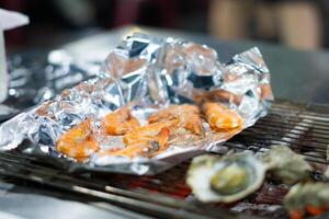 grillen lekkernijen, garnaal zeevruchten, barbecue sissend Aan aluminium folie in Taiwan foto
