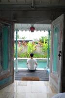 zwembad rust, Aziatisch model- in lotus yoga houding, Bali villa ontspanning foto