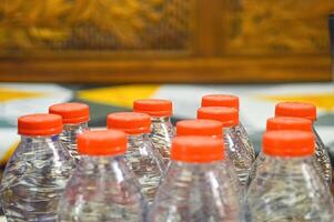 veel plastic mineraal water flessen met oranje petten Aan vervagen achtergrond foto