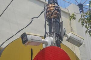 een cctv toezicht camera gehecht naar een elektriciteit pool is toezicht houden de stad foto