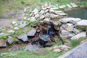 dichtbij omhoog van een klein waterval morsen over- mos gedekt rotsen in regionaal park. handgemaakt rivier- waterval foto