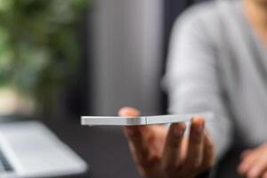 detailopname beeld van een vrouw Holding en gebruik makend van mobiel telefoon Aan houten tafel in cafe. vrouw Speel mobiel spel. beeld van een vrouw in werking een smartphone. foto