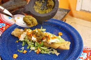 traditioneel tostada, klassiek van Mexicaans keuken met sla, gehakt tomaten, gebakken kip chips foto
