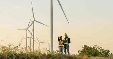 ingenieurs zijn werken met wind turbines, groen ecologisch macht energie generatie, en duurzame windmolen veld- boerderijen. alternatief hernieuwbaar energie voor schoon energie concept. foto