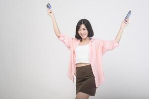 Aziatisch glimlachen vrouw Holding credit kaart over- wit achtergrond studio, boodschappen doen en financiën concept. foto
