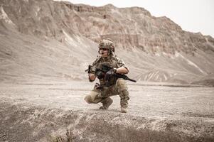 soldaten in camouflage uniformen het richten met hun geweren gereed naar brand gedurende leger operatie in de woestijn soldaten opleiding in een leger operatie foto