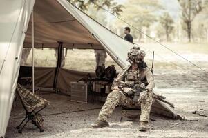 soldaten in camouflage uniformen planning Aan operatie in de kamp, soldaten opleiding in een leger operatie foto