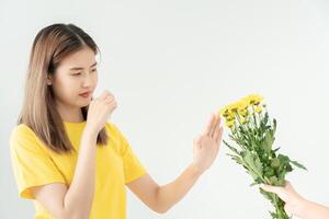 stuifmeel allergieën, Aziatisch jong vrouw niezen in een zakdoek of blazen in een veeg, allergisch naar wild voorjaar bloemen of bloesems gedurende de lente. allergisch reactie, ademhalings systeem problemen foto