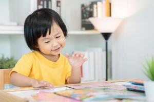 gelukkig Aziatisch kinderen kom tot rust lezen boek Bij huis. dochter en lezing een verhaal. leren ontwikkeling, kinderopvang, lachend, opleiding, verhaal vertellen, oefening, stel je voor, verminderen verslaving mobiel telefoon foto