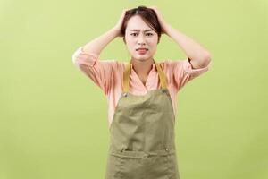 foto van jong Aziatisch vrouw huishoudster Aan groen achtergrond