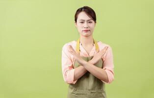 foto van jong Aziatisch vrouw huishoudster Aan groen achtergrond