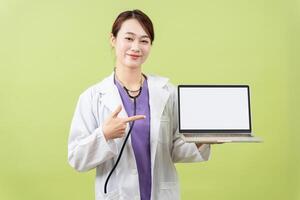 foto van jong Aziatisch vrouwelijk dokter Aan groen achtergrond