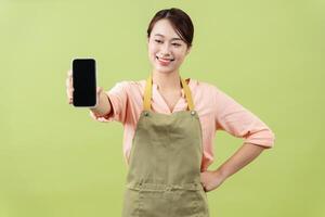 foto van jong Aziatisch vrouw huishoudster Aan groen achtergrond