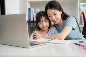 foto van jong Aziatisch moeder en dochter aan het studeren Bij huis