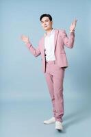 foto van jong Aziatisch zakenman vervelend roze pak Aan achtergrond