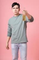 foto van jong Aziatisch Mens drinken alcohol Aan achtergrond