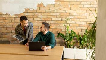 samenwerking in beweging, professionals werken samen in een modern met bakstenen muren kantoor foto