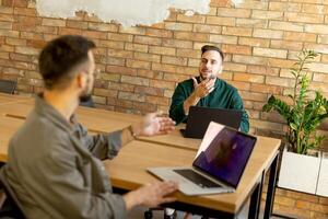 samenwerking in beweging, professionals werken samen in een modern met bakstenen muren kantoor foto