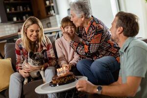 vreugdevol familie vieren grootmoeders verjaardag met taart in een knus leven kamer foto