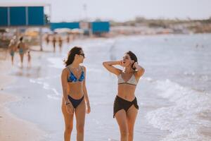 twee mooi jong vrouw hebben pret Aan de kust foto