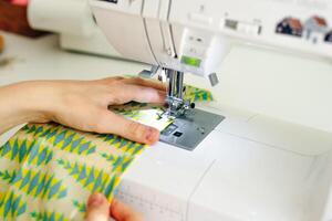 vrouw handen stiksels wit kleding stof Aan professioneel fabricage machine Bij werkplaats foto