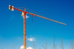 geel industrieel kranen werken Aan bouw plaats tegen blauw lucht foto