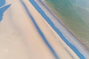 kust van een strand Bij zonsopkomst Bij laag tij antenne visie met dar foto