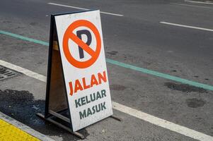 een bord met een teken dat Nee parkeren is toegestaan Aan de kant van de weg. vertaling Aan bord Ingang en Uitgang. foto