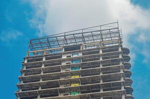 een hoog stijgen gebouw van wie bouw heeft niet geweest voltooid en is verlaten gedurende de dag met kopiëren ruimte foto