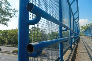 een hek uitgerust met een ijzer netto voor veiligheid Aan de voetganger kruispunt brug over- de tol weg foto