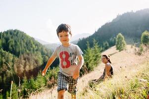 jong mam met baby jongen reizend. moeder Aan wandelen avontuur met kind, familie reis in bergen. nationaal park. wandeltocht met kinderen. actief zomer vakantie. vissenoog lens. foto