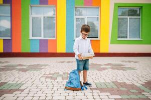 schattig schooljongen in wit overhemden en een bril met boeken en een rugzak. terug naar school. foto