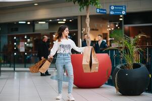 kleinhandel, gebaar en uitverkoop concept - glimlachen tiener- meisje met veel boodschappen doen Tassen Bij winkelcentrum. foto