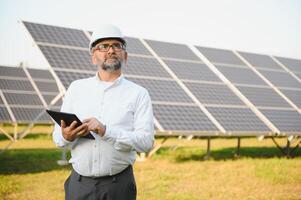 zonne- macht fabriek. Mens staand in de buurt zonne- panelen. hernieuwbaar energie foto