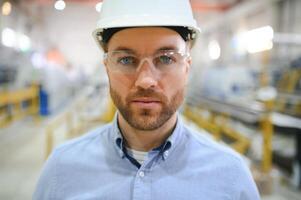 portret van zelfverzekerd knap technisch ingenieur in harde hoed. foto