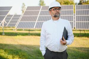 senior ingenieur werken Aan zonne- paneel boerderij. de concept van groen energie foto