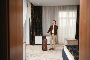 Kaukasisch midden volwassen zakenman pratend met mobiel telefoon in hotel kamer gedurende bedrijf reis foto