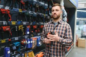 knappe jonge man winkelen voor tools op ijzerhandel foto