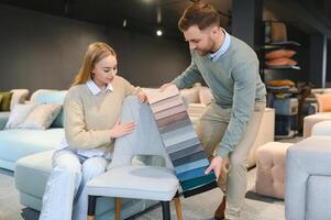 vrouw en Mens op zoek Bij textiel swatch in meubilair op te slaan foto