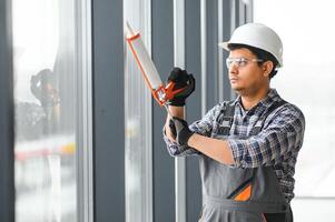 werkman in overall installeren of aanpassen plastic ramen foto