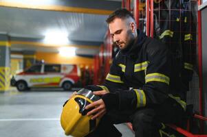 portret van mannetje brandweerman in uniform Bij brand station foto