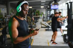 Afrikaanse Amerikaans Mens luisteren motiverende muziek- over- hoofdtelefoons verbeteren kwaliteit van training foto