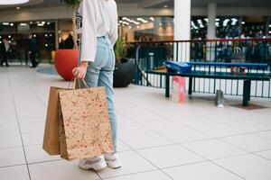 boodschappen doen tijd, detailopname van tiener- meisje poten met boodschappen doen Tassen Bij boodschappen doen winkelcentrum. foto