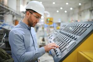 een jong mannetje ingenieur inspecteert de productie van plastic venster kaders foto