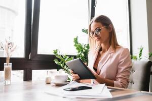 glimlachen zakenvrouw gebruik makend van tablet computer koffie winkel. foto